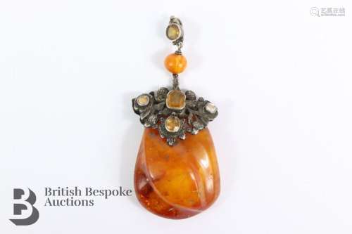 Antique natural butterscotch amber pendant having a carved f...
