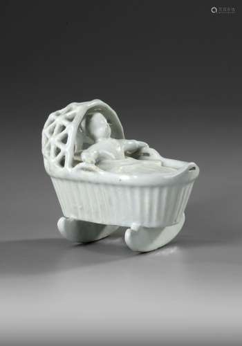 A WHITE DELFT MODEL OF A BABY IN A CRADLE, END OF 18TH CENTU...