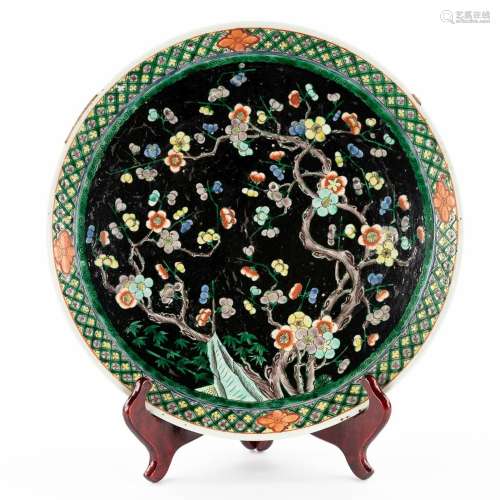 A Chinese plate 'Famille Noir', decorated with flowers and b...