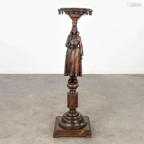 A pedestal with a wood sculptured figurine in Breton style. ...
