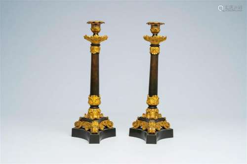 A pair of French gilt and patinated bronze candlesticks with...