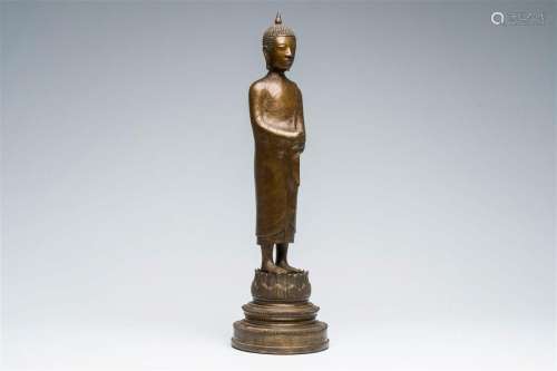 A Thai patinated bronze figure of a standing Buddha with ins...