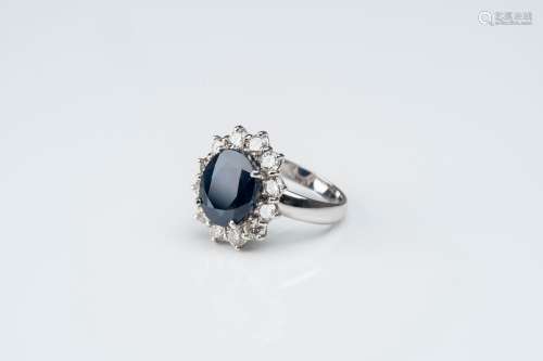 An 18 carat white gold ring set with a sapphire and twelve d...