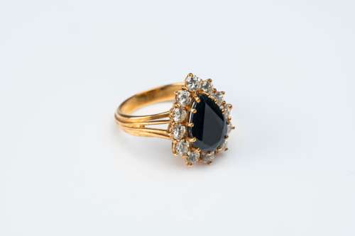 An 18 carat yellow gold ring set with a pear-shaped sapphire...