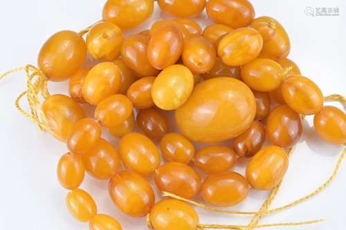 A STRING OF GRADUATED AMBER BEADS