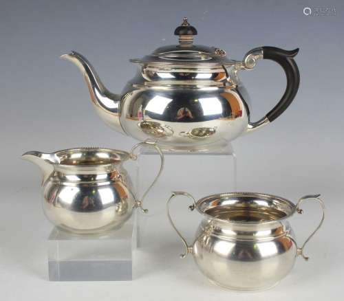A George V silver three-piece tea set of squat circular form...