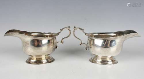 A pair of George V silver sauceboats, each with shaped rim a...