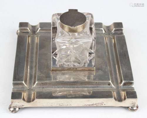 A George V silver square inkstand, fitted with a central cut...