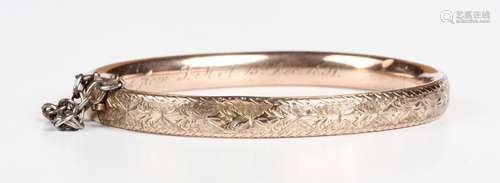 A Victorian gold oval hinged bangle, the front with engraved...