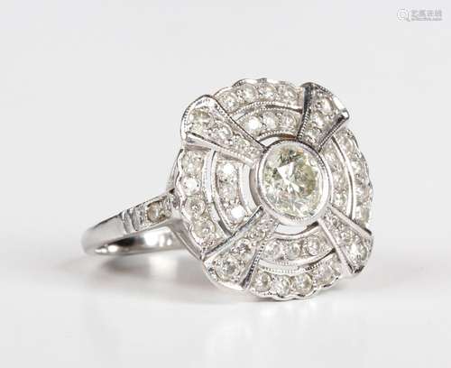 A white gold and diamond shaped circular cluster ring, colle...