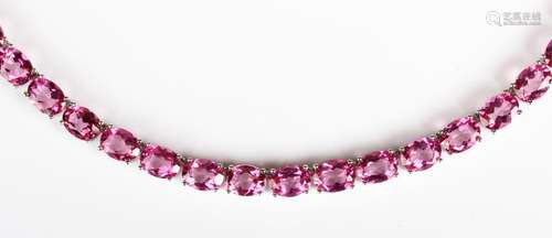 A silver and treated pink topaz necklace, claw set with a ro...