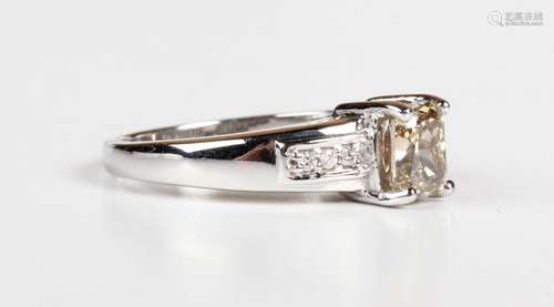 An 18ct white gold ring, claw set with a cushion cut light b...