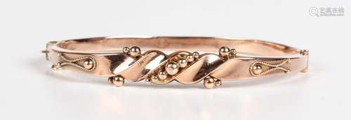 A 9ct gold oval hinged bangle, the front with applied bead a...