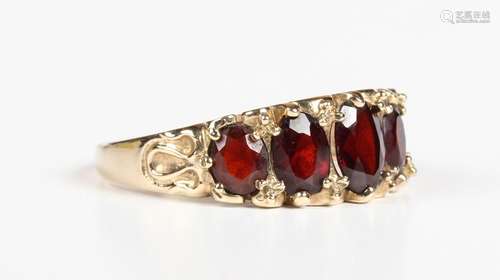 A 9ct gold and garnet five stone ring, mounted with a row of...