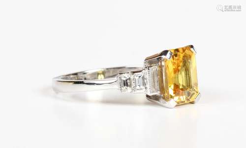 A platinum, yellow sapphire and diamond ring, claw set with ...