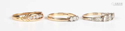 A 9ct gold and diamond three stone ring, mounted with a row ...