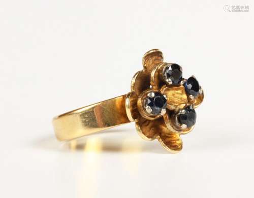A gold and sapphire four stone ring in an abstract design, d...