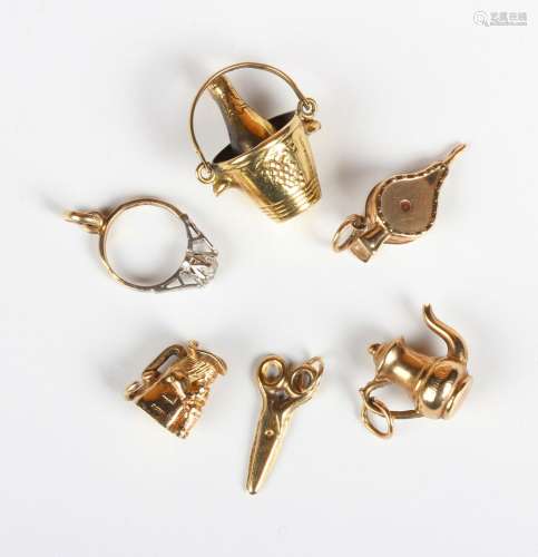Six 9ct gold charms, including a Toby jug, a pair of bellows...
