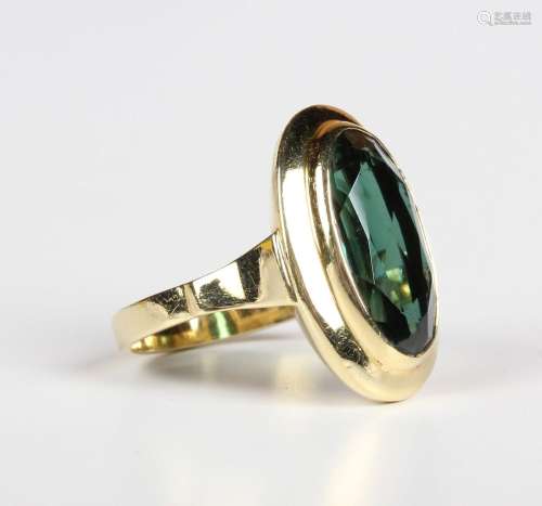 A gold ring, collet set with an oval cut synthetic green spi...