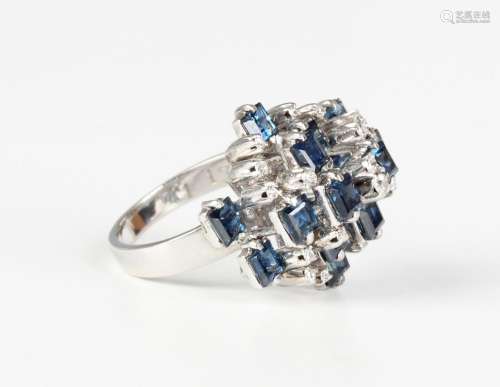 A white gold, sapphire and diamond cluster ring in a raised ...