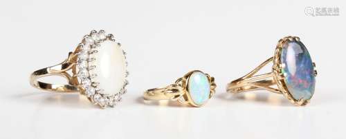 A gold ring, mounted with an oval opal between foliate shoul...