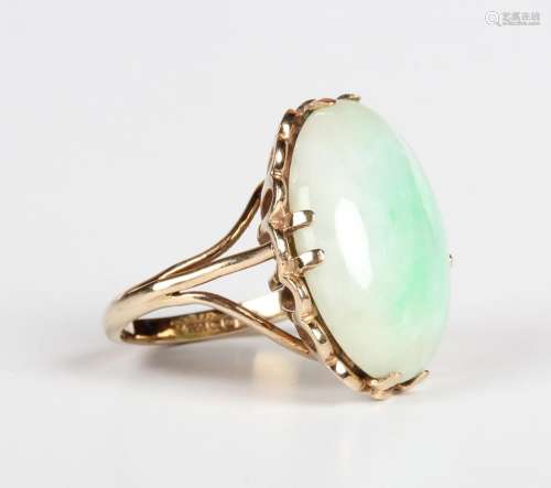 A 9ct gold ring, claw set with the oval cabochon jade betwee...