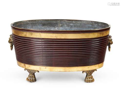 A LARGE MAHOGANY AND GILT BRASS OVAL WINE COOLER, IN THE REG...