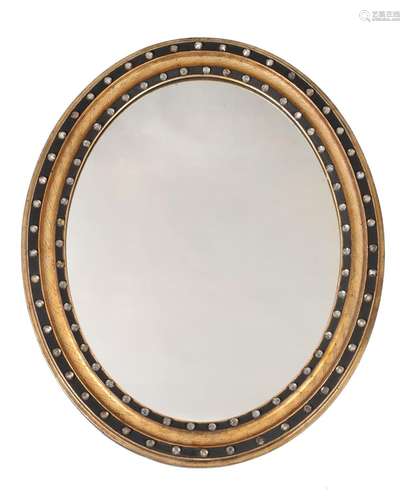 AN IRISH CUT GLASS, GILTWOOD AND EBONISED OVAL WALL MIRROR, ...