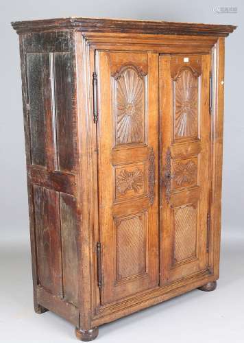 A 17th century French oak armoire, the two panelled doors ca...