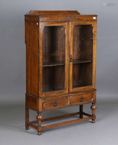 A George V oak glazed bookcase, fitted with two drawers, hei...