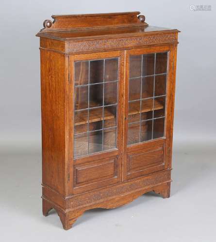 An early/mid-20th century oak glazed bookcase with blind fre...