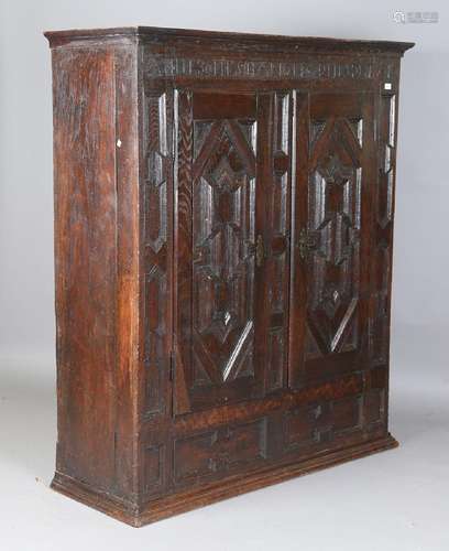 A 17th century oak cupboard, the two doors with overall appl...