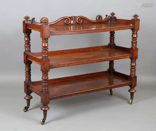 A mid-Victorian mahogany three-tier buffet with a carved gal...