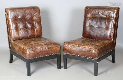 A pair of modern buttoned brown leather easy chairs with bra...