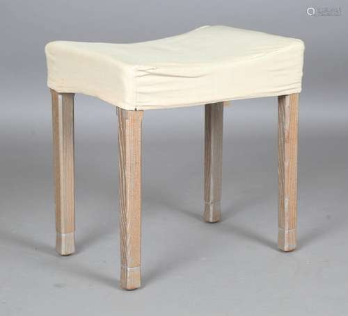 An Elizabeth II limed oak coronation stool with blue velvet ...