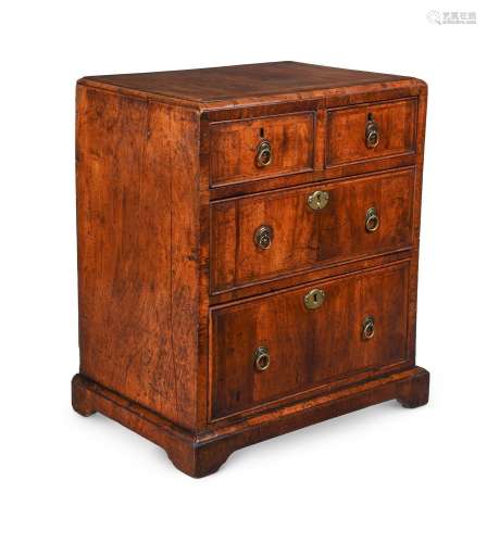 A GEORGE II WALNUT AND FEATHER BANDED MINIATURE CHEST OF DRA...