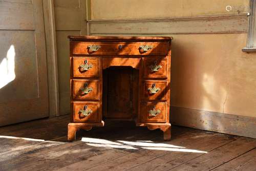 A GEORGE II WALNUT AND CROSSBANDED KNEEHOLE DESK, CIRCA 1730