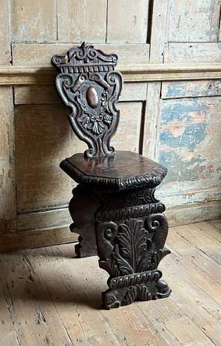 AN ITALIAN CARVED WALNUT SGABELLO HALL CHAIR, 16TH/17TH CENT...