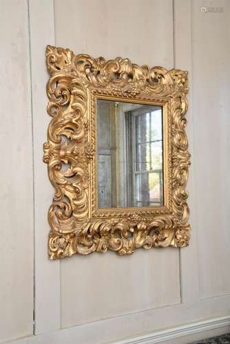 AN ITALIAN CARVED GILTWOOD WALL MIRROR, POSSIBLY FLORENTINE,...