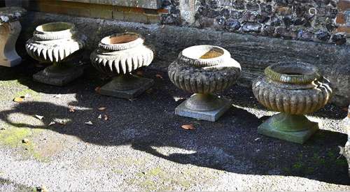 A SET OF FOUR COMPOSITION STONE URNS, IN REGENCY STYLE, 20TH...