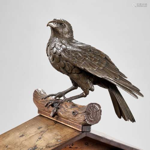 AN UNUSUAL BRONZE AND WOOD GROUP DEPICTING A HAWK ON A BIRDH...