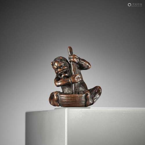 ITTAN: A FINE NAGOYA SCHOOL WOOD NETSUKE OF AN ONI WITH MORT...