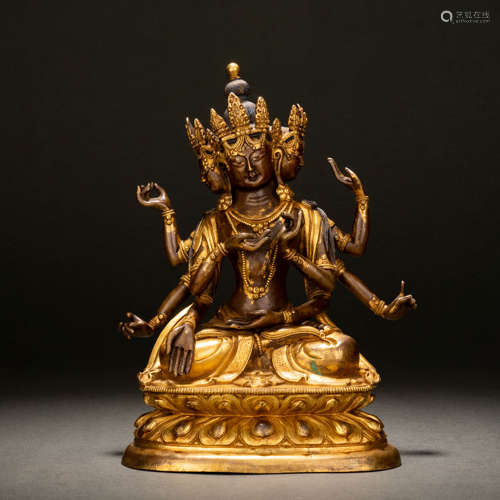 A gilt bronze statue of Buddha with eight arms and three fac...