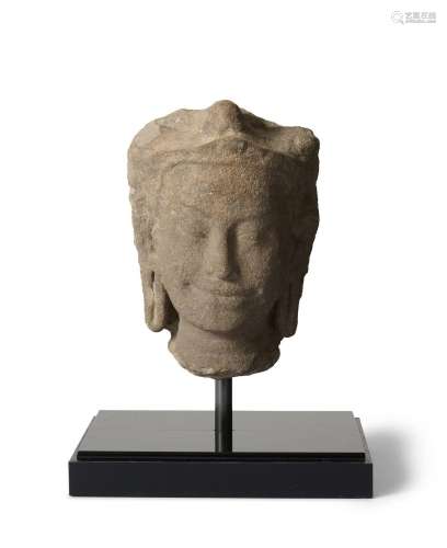 A KHMER SANDSTONE HEAD OF AN APSARA CIRCA 10TH CENTURY