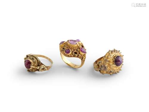 TWO INDONESIAN RUBY-SET GOLD RINGS AND A GOLD PLATED RING JA...