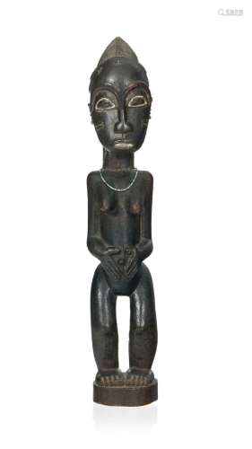 Statuette féminine Baoulé, le visage scarifié, les bras rame...