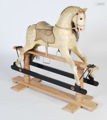 A carved and painted wood rocking horse in the style of F. H...