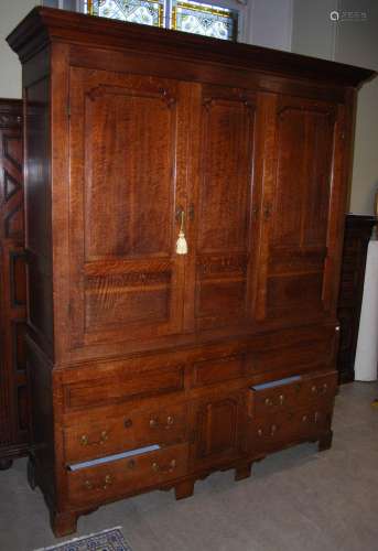 A 19th century oak press cupboard, the moulded cornice above...