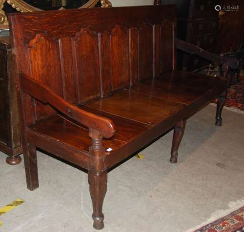 A George III oak settle, with fine panel back and planked se...