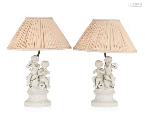 Paire de lampes, XXe s., en biscuit figurant deux enfants jo...